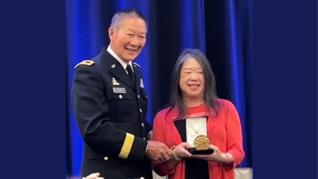 Joanne Young posing with Major General Stephen Tom after receiving a Congressional Gold Medal on behalf of her uncle Leonard Kwong Johe