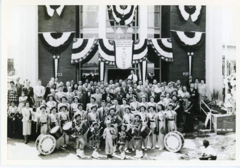 Black and white photo of group posing in front of CCBA building during grand opening of the Chinese Benevolent Association