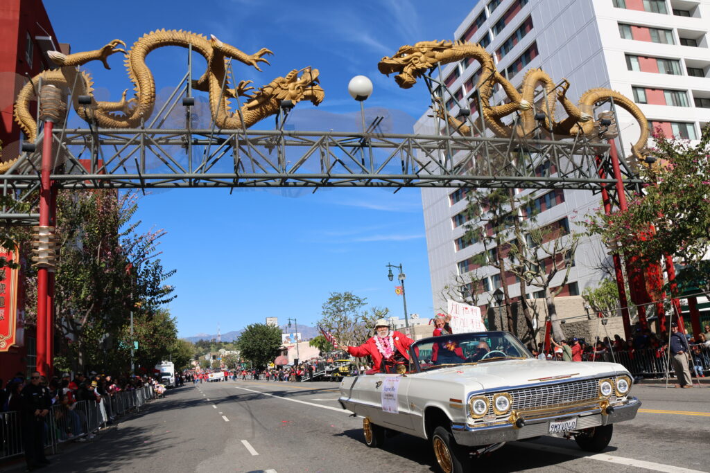 Grand Marshal Eugene Moy and wife Susan Sing crossing under the Golden Dragon entrance into Los Angeles Chinatown. Photo courtesy of O.C. Lee.