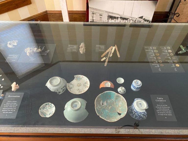 Photo of front display room showing detailed view of the artifacts in the display case with more dishes