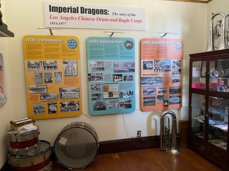 Photo of the Drum & Bugle Display room with more information posters on the left side wall, drums and bugle on the floor