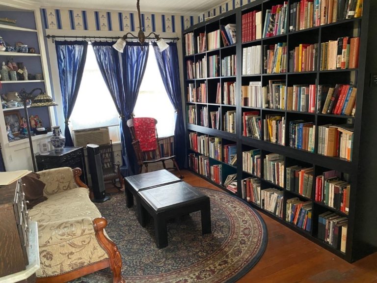 Photo the CHSSC Library with couch, coffee table and a wall covered by a bookshelf full of books