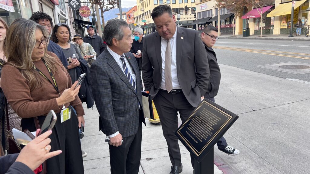 Pasadena Councilmember Gene Masuda and Pasadena Mayor Gordo discussing the plaque on Fair Oaks Ave.